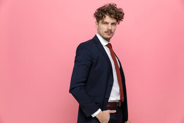 young elegant fashion model in suit holding hands in pockets