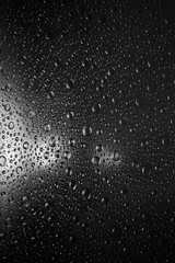 abstract black background with lights reflected in surface splashed with water drops