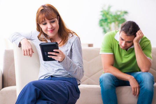 Young couple in gadget dependency concept
