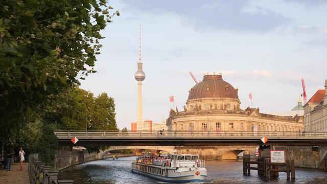 Berlin city center buildings architecture view with river Spree embankment, bridge and TV tower needle in evening time on summer
