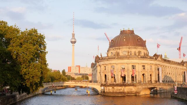 Berlin city center buildings architecture view with river Spree embankment, bridge and TV tower needle in evening time on summer