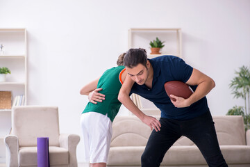 Father and son doing sport exercises indoors