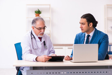 Obraz premium Young businessman meeting with old doctor