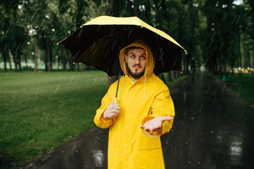 Man with umbrella walking in park in rainy day