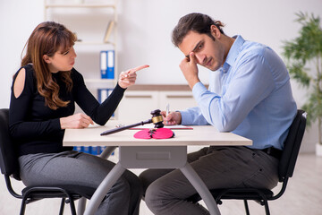Fototapeta premium Young pair in courthouse in divorcing concept