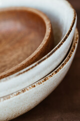 Macro abstract photography of modern minimalist ceramics set and wooden bowl.