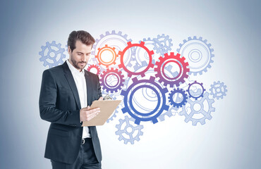 Man with clipboard, gears sketch