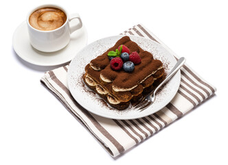 portion of Classic tiramisu dessert with raspberries, blueberries and cup of fresh hot espresso isolated on white background - clipping path