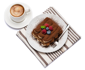 portion of Classic tiramisu dessert with raspberries, blueberries and cup of fresh hot espresso isolated on white background - clipping path