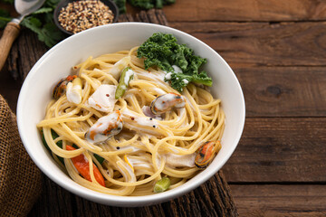 spaghetti cream sauce with mussels on wood