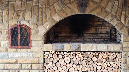 Fototapeta na wymiar Fire-resistant stone outdoor barbecue area with wood. Outdoor recreation area with barbecue.