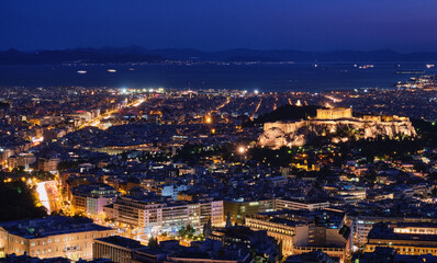 Fototapeta na wymiar Night view of Athens and Acropolis from Lycabettus hill, Parthenon, Saronic Gulf, Hellenic Parliament. Famous iconic view of UNESCO world heritage.