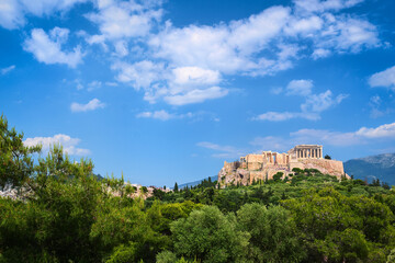 Fototapeta na wymiar Beautiful view of Acropolis hill in Athens, Greece from Pnyx hill in summer day with great clouds in blue sky. Famous ancient UNESCO heritage site