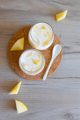 Delicious sweet cream ice cream dessert with melon in glasses on wooden background