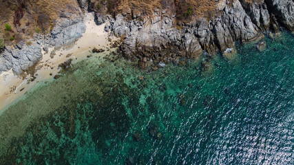 Aerial view. Top view of turquoise sea water washes the rocky shore in Thailand, Phuket. Landscape background