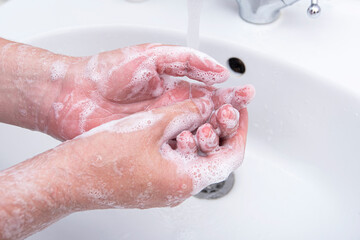 Fototapeta premium Man washing his hands by soap with foam, concept picture about virus and hygiene 