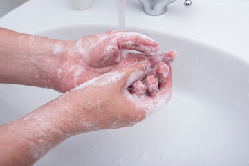 Fototapeta premium Man washing his hands by soap with foam, concept picture about virus and hygiene 