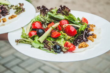 Serving the salad. Fine cuisine in a restaurant