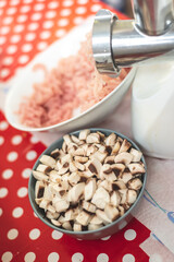 the kitchen table during the preparation of a meal, chopped mushrooms and minced meat