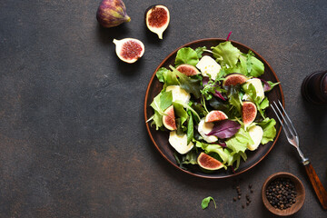 Mix salad with figs and brie cheese on a concrete background