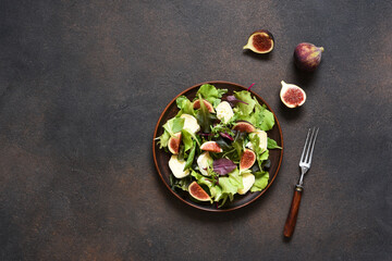 Mix salad with figs and brie cheese on a concrete background