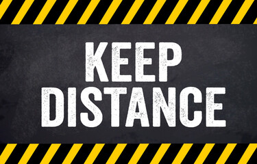 Black chalkboard with message Keep Distance - social distancing