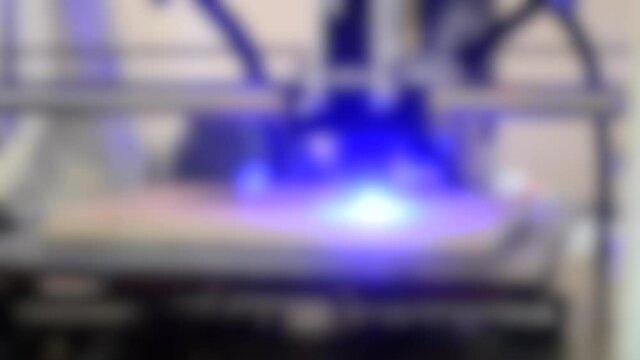 Blurred background. Laser engraving on wood. 3D printer laser beam burns