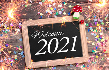 Chalkboard with four leaf clover and chimney sweeper and sparklers with happy new year 2021 on...