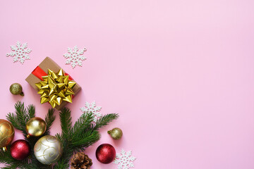 Beautiful composition. Christmas pink background with fir, christmas gifts and decor. Top view with space for copy.