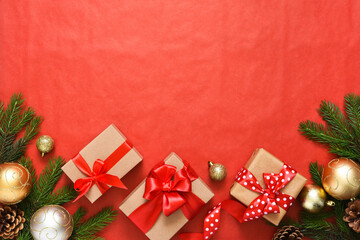 Fototapeta na wymiar Beautiful Christmas composition on a red background with fir. Gift boxes with red ribbons.