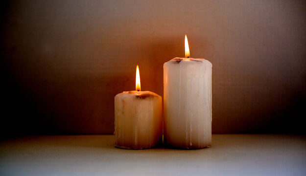 two old candles with fire on the white background