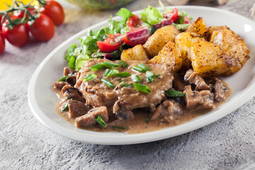 Pork loin chop with mushroom sauce and baked potatoes