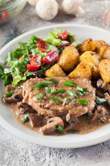 Pork loin chop with mushroom sauce and baked potatoes