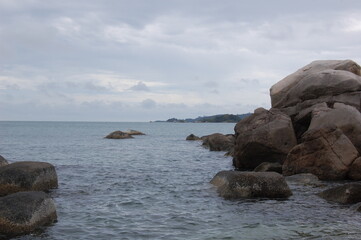 アジアの熱帯のリゾートアイランドの海岸から見た岩礁と熱帯雨林と水平線