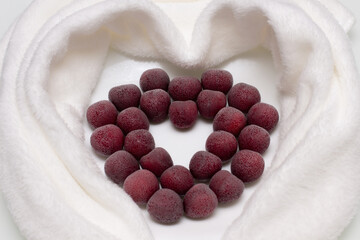  Heart shape made from sweet cherry berries with hoarfrost on white background