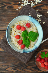 Delicious oatmeal porridge with ripe raspberries. Healthy and hearty Breakfast. The concept of diet and vegetarian food for a slim figure lifestyle