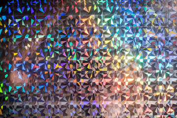 macro photo of silver rainbow holographic foil, colorful hologram surface, glitter grid pattern...