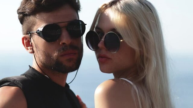 Portrait of man and woman in sunglasses kissing passionately