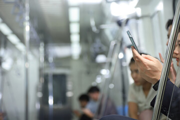 Hand of people holding cellphone while taking metro subway train to work with copy space