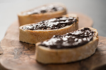 Rustic ciabatta with organic chocolate cream on olive wood board