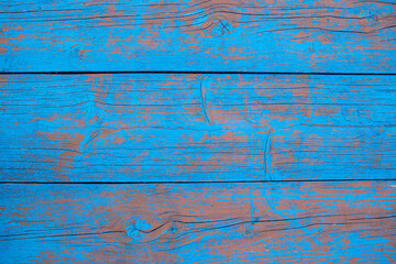 Fototapeta na wymiar wooden textured vintage background of old wood wide boards. Peeling paint on an old blue and red wooden floor.