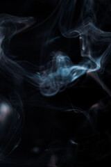 White smoke from incense stick isolated against dark background