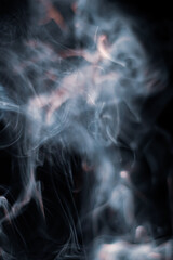 White smoke from incense stick isolated against dark background