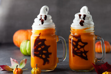 Halloween Pumpkin  cocktail with whipped cream in ghost shape and chocolate spider web. Freakshake...