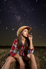 Woman farmer smoking a cigar at night
