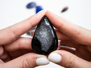 Pendant made of natural black agate in a woman's hand