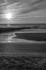 Sunset with breakwaters on a summer night in black and white