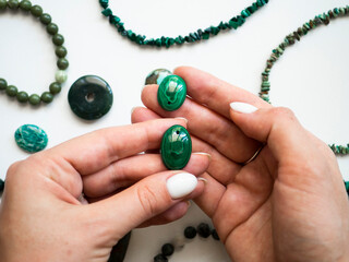 Pendant made of natural malachite in a woman's hand