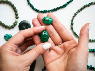 Pendant made of natural malachite in a woman's hand