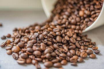 Geröstete Kaffee Bohnen fallen aus einer weißen Dose 